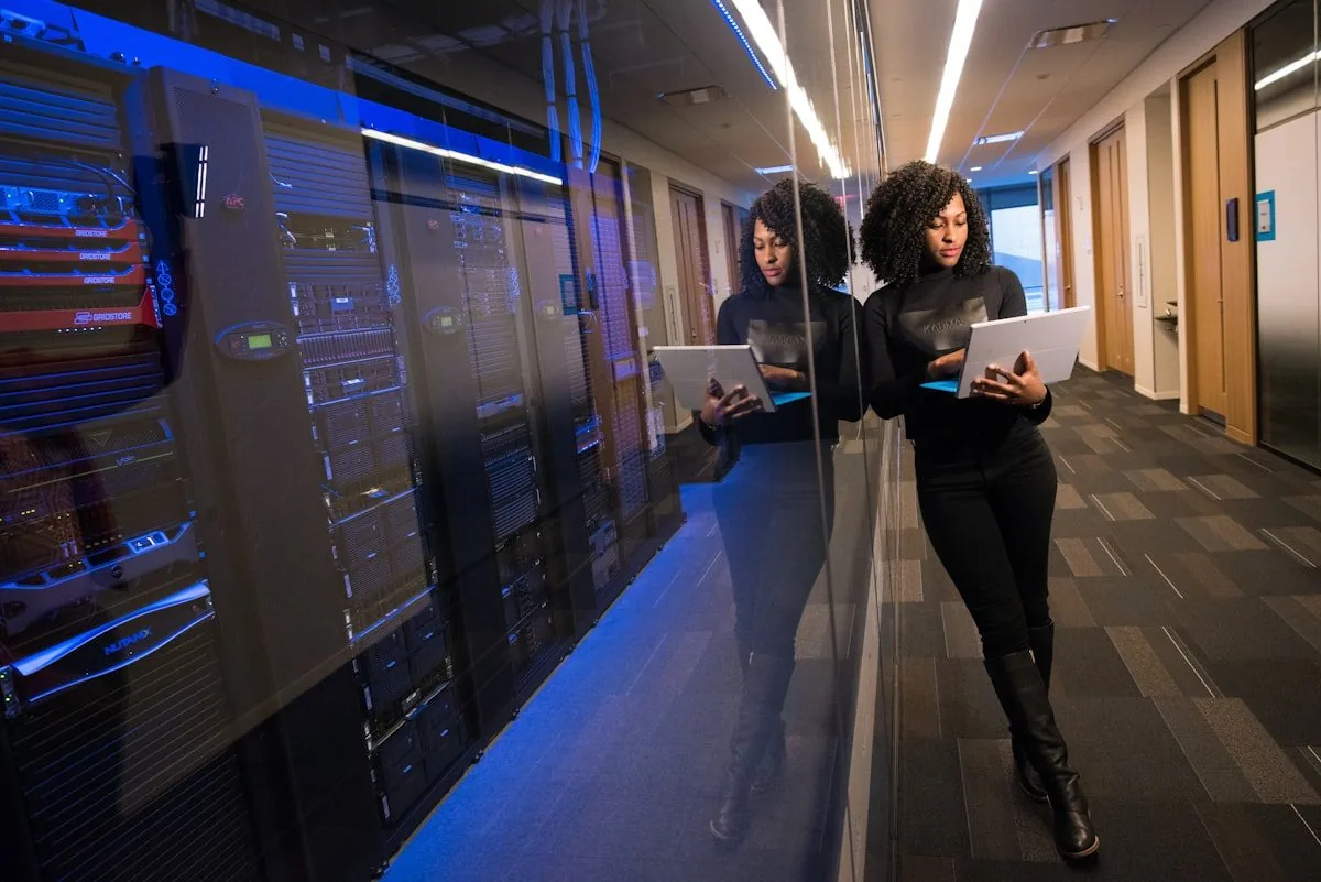 Two people with a tablet in a data centre corridor