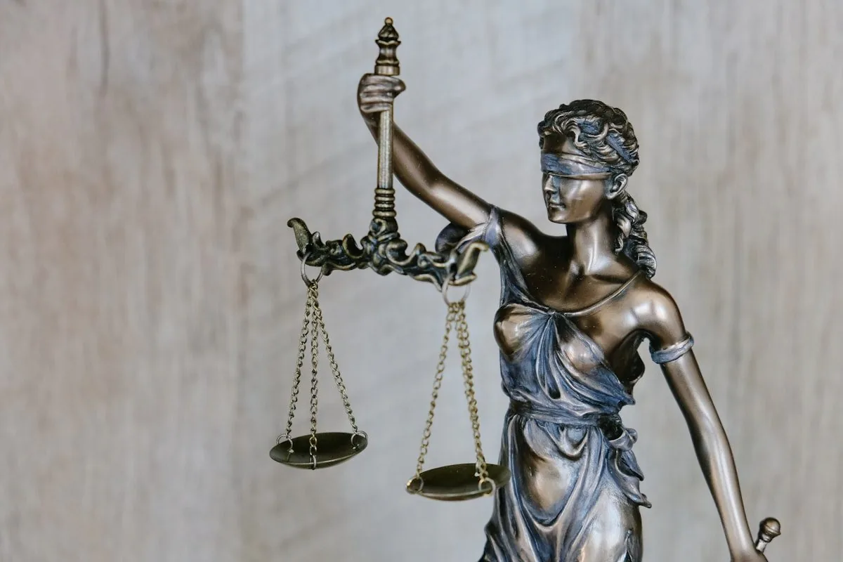 A bronze statue of a blindfolded Lady Justice holding a set of scales
