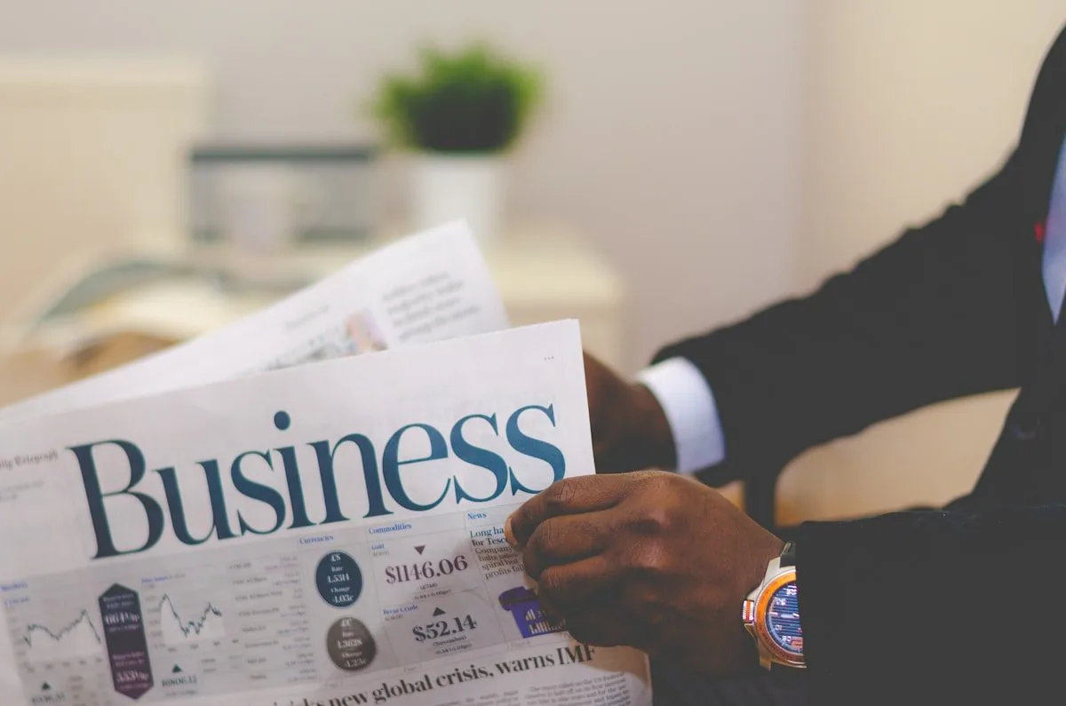 A person in a suit reading the business pages of a newspaper
